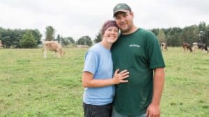 couple hugging with dairy cows in background