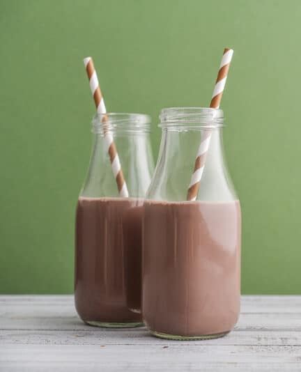 Glass of chocolate milk with gable top package close up. Cow cocoa