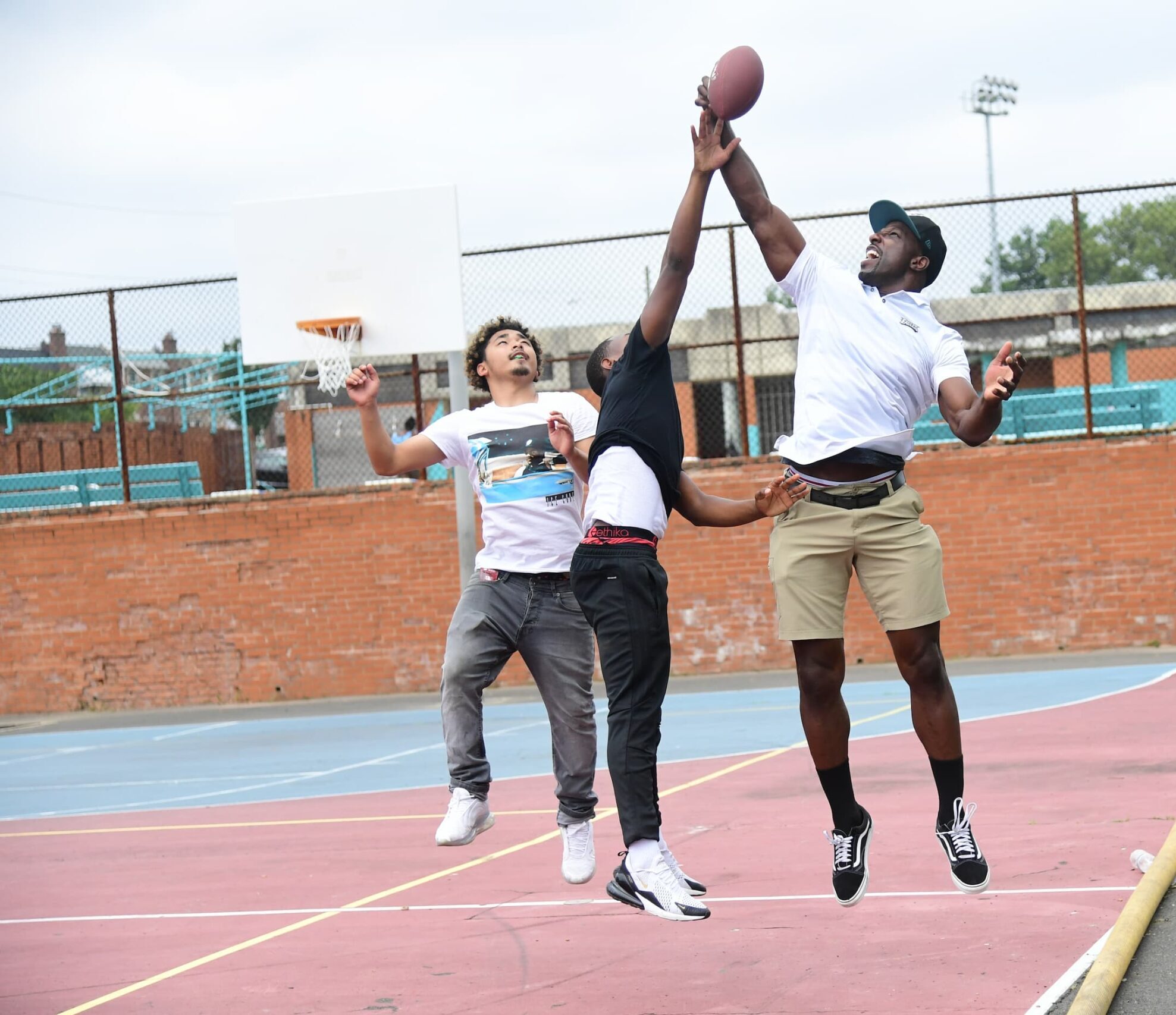 Men playing with a football on a basketball court